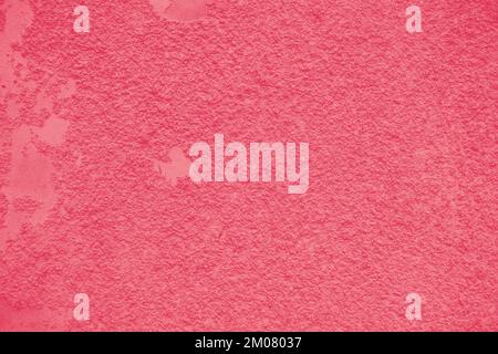 Hintergrund einer abblätternden Magenta-Farbe an einer alten strukturierten Wand. Farbe Des Jahres 2023 - Viva Magenta. Stockfoto