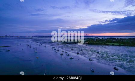 Portsmouth Harbour bei Nacht, während die rosa Sonnenuntergänge mit Booten am Porchester Castle vor Anker gehen Stockfoto