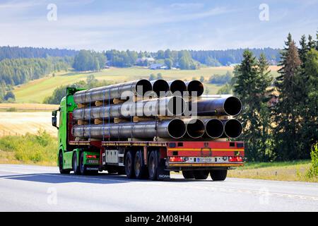 Limettengrün Scania fährt an einem Sommertag vor einem Auflieger Metallrohre entlang der Autobahn. Rückansicht. Pirkanmaa, Finnland. 11. August 2022 Stockfoto
