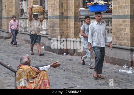 Gepäckträger mit Fischkörben auf dem Kopf, am Chhatrapati Shivaji Maharaj Terminus (CMST) in Mumbai, Indien, um die Körbe mit dem Zug weiterzuleiten Stockfoto