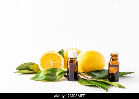 Zwei medizinische Flaschen mit ätherischem Öl oder Zitronenessenz für kosmetische Selbstpflege. Wellnessbehandlungen. Aromatherapie. Vorderansicht. Weißer Hintergrund Stockfoto