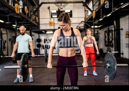 Gruppe junger Sportler im Fitnessraum. Stockfoto