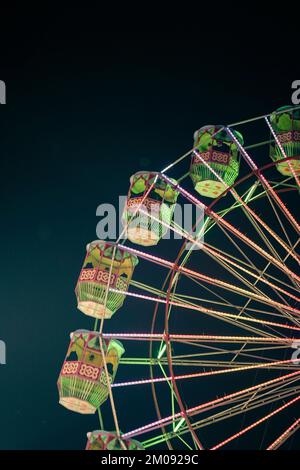 Riesenrad mit grüner Beleuchtung in einer Ausstellung indische Messe bei Nacht, Indische Messe Riesenrad. Stockfoto