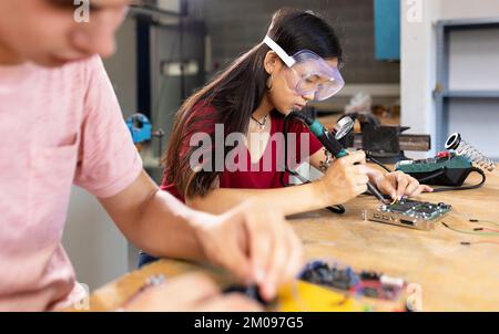 Junge asiatische Schülerin, die Roboter baut, im Ingenieurunterricht an der Highschool Stockfoto