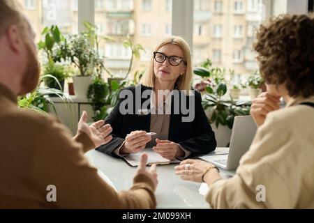 Porträt eines reifen weiblichen Beratungspaares in der Versicherungsagentur Stockfoto