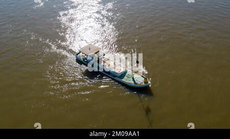 Luftaufnahme eines Dredgenschiffs, der Flusssand auf der Oberfläche des ruhigen Meeres entfernt Stockfoto