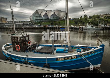 Trawler auf Tyne in Newcastle mit Sage Centre dahinter Stockfoto