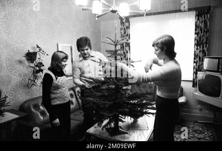 Arbeitslose im Arbeitsamt Dortmund und zu Hause in Dortmund am 17.12.1974. Arbeitslose mit einer kleinen Familie, Deutschland, Europa Stockfoto