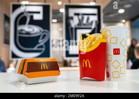 Big Mac Box mit McDonald's Logo, Pommes Frites und alkoholfreie Getränke in McDonald's Restaurant. Stockfoto