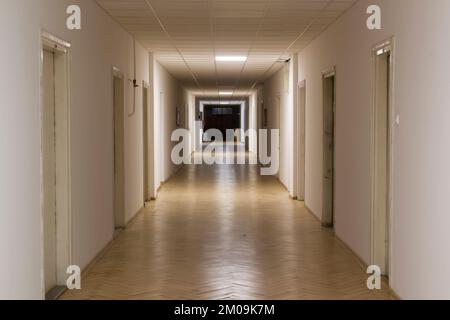 Korridor des alten Geschäftsgebäudes mit Türen und Holzfußboden Stockfoto