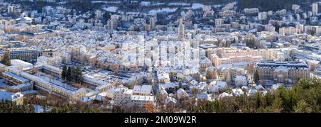 Erhöhter Panoramablick auf schneebedeckte Dächer in der Stadt Gap im Winter. Hautes-Alpes, Alpen, Frankreich Stockfoto