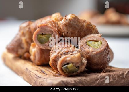 Fleischbrötchen gefüllt mit Senf und eingelegter Gurke in Soße geschmort Stockfoto