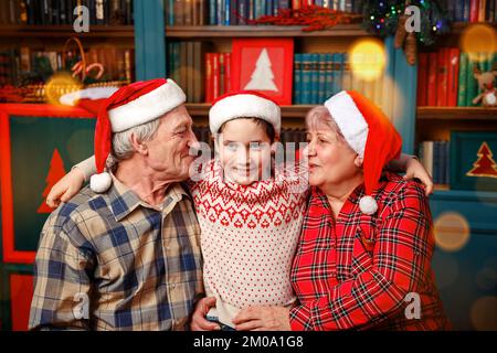 Lächelnde Großeltern und Enkel, die zu Hause auf der Couch sitzen. Stockfoto