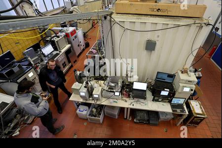 05. Dezember 2022, Mecklenburg-Vorpommern, Rostock: In der Forschungshalle der Fakultät für Maschinenbau und Schiffstechnik der Universität steht ein aus München stammendes mobiles Biologisches Labor (r) neben anderen Test- und Laborgeräten. An der Universität wurde eine internationale Messkampagne gestartet, um die gesundheitlichen Gefahren von Feinstaubemissionen und Luftverschmutzung durch Flugzeugturbinen und Schiffsmotoren zu untersuchen. Die Messungen erfolgen im Rahmen des ULTRHAS-Projekts (ultrafeine Partikel aus dem Transport - Health Assessment of Sources). Das Projekt Stockfoto