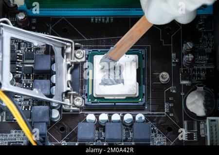 Draufsicht Techniker, der Silikon-Kühlung auf CPU-Chips anwendet Stockfoto