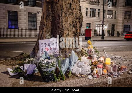 Blumen und Kerzen wurden in der Wache in Erinnerung an die Tragödie gesehen, in der letzte Woche in Urumqi 10 Menschen aufgrund der COVID-Lockdown-Politik in China während der Demonstration vor der chinesischen Botschaft in London getötet wurden. Chinesische Studenten, die derzeit in London studieren, versammelten sich bei der chinesischen Botschaft in London, um gegen die Lockdown-Politik in China zu protestieren. Letzte Woche kam es in China zu einer massiven Welle von Protesten, da 10 Menschen in einem Urumqi in der Nordwestregion Chinas aufgrund der unmenschlichen COVID-Lockdown-Politik getötet wurden. Stockfoto