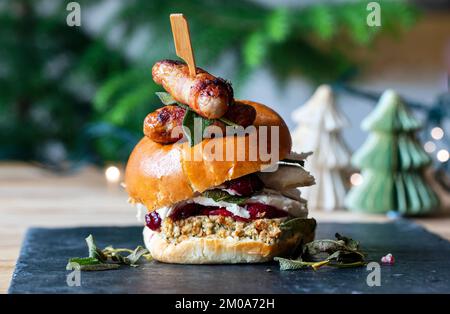 Weihnachtsbrötchen mit truthahn, Füllung, Preiselbeersoße und Schweinen in Decken Stockfoto