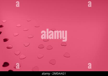 Rote Herzen Konfetti auf festlichem Hintergrund in Farbe des Jahres 2023 Viva Magenta. Love, Dating und St. Valentinstag Konzept. Selektiver Fokus, Kopierbereich Stockfoto