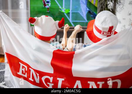 Vater und Sohn mit englischer Flagge, die Fußballspiele im Fernsehen sehen Stockfoto