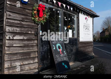 Floristen kaufen das Geschäft Forge Flowers, das für weihnachtskränze-Workshops zur Weihnachtszeit wirbt, Halnaker, West Sussex, England, Großbritannien. Stockfoto