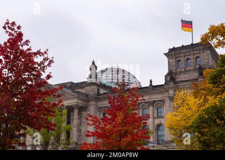 Blick auf den Reichstag in Herbstfarben mit deutscher Flagge. Mitte, Berlin, Deutschland, Europa. Stockfoto