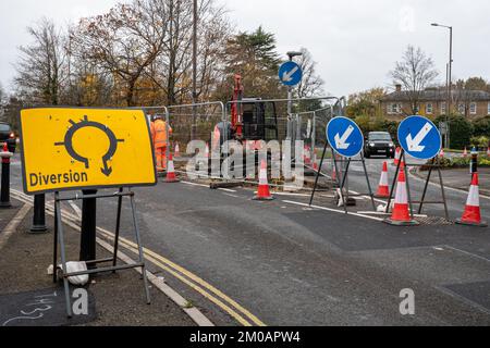 Straßenarbeiten mit gelbem Umlenkschild an einem Kreisverkehr in Farnborough, Hampshire, England, Großbritannien Stockfoto
