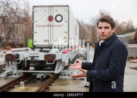 05. Dezember 2022, Sachsen, Leipzig: Nicolas Albrecht, CEO CargoBeamer, erläutert, wie ein Auflieger an einem Güterbahnhof mit einer neuen Ladetechnik auf einen Eisenbahnwaggon geladen wird. Das Leipziger Unternehmen CargoBeamer will den Güterverkehr in Europa effizienter und umweltfreundlicher gestalten. Im neu entwickelten Terminal können Lkw-Anhänger mit Hilfe einer sogenannten Laderampe seitlich auf den Waggon gefahren werden. Dadurch wird das Problem umgangen, dass fast alle Lkw-Anhänger nicht mit einem Kran angehoben werden können, was die Beladung der Schiene kostspielig und nicht lohnenswert macht. Der erste termin der Firma Stockfoto