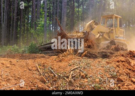 Arbeiten mit Traktor während der Entwaldung Landschaftsbau für die Vorbereitung Baustelle mit Entfernen von Wurzeln Stockfoto