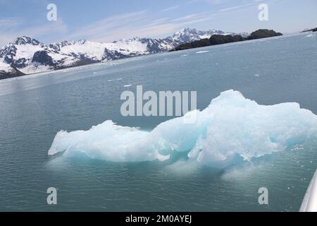 Eisscholle im Wasser mit Bergen Stockfoto