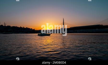 Wunderschöner Sonnenuntergang, Goldene Stunden, Golden Horn Metro Bridge und der Blick auf das Goldene Horn in Istanbul, Sonnenuntergang, Vögel, die in Richtung Sonne fahren, T Stockfoto