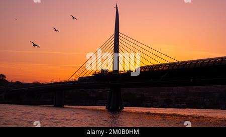 Wunderschöner Sonnenuntergang, Goldene Stunden, Golden Horn Metro Bridge und der Blick auf das Goldene Horn in Istanbul, Sonnenuntergang, Vögel, die in Richtung Sonne fahren, T Stockfoto