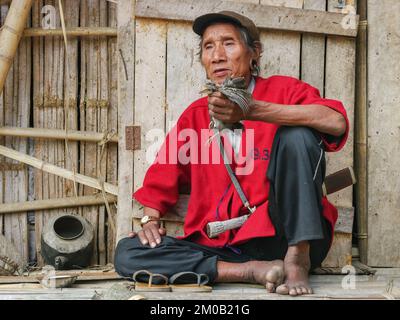 Raga, Arunachal Pradesh, Indien - 02 20 2013 : Ganzkörperportrait des Nyishi-Stammes, männlicher Schamane, der junge Hühner im traditionellen Ritual opfert Stockfoto