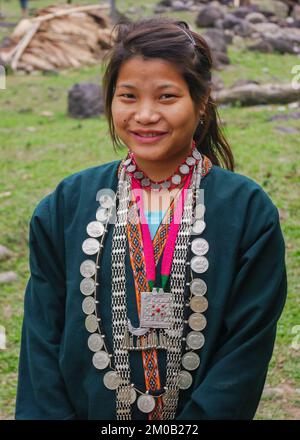 East Siang, Arunachal Pradesh, Indien - 03 08 2014 : Außenporträt eines jungen Mädchens des Stamms Adi Padam in traditionellem Zeremonialkleid und Halsketten Stockfoto