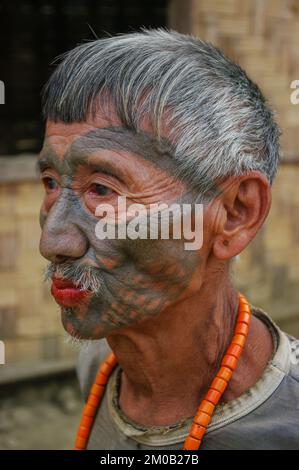 Mon District, Nagaland, Indien - 03 09 2014 : Portrait des alten Naga Konyak Stamm-Kopfjäger-Kriegers mit traditionellem Gesichtstattoo und Korallenkette Stockfoto