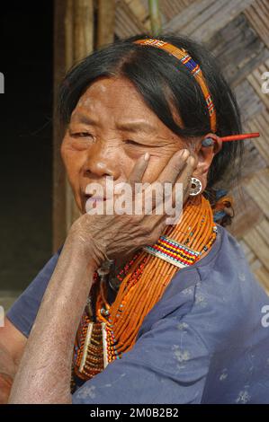 Mon District, Nagaland, Indien - 03 11 2014 : Porträt der alten Naga Konyak-Stammesfrau mit Halskette, Kopfband und Stachelschweinen in den Ohren Stockfoto