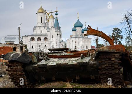 Swjatohirsk, Ukraine. 30.. November 2022. Ein zerstörter russischer Panzer steht an der Straße vor einem orthodoxen Tempel in der befreiten Stadt Sviatohirsk. Russland verliert täglich zwischen 50 und 100 Soldaten in der Schlacht von Bakhmut inmitten seiner verzweifelten Versuche, die Stadt in der Oblast Donezk zu erobern, sagte ein militärischer Sprecher am 4. Dezember. Serhiy Cherevaty, Sprecher des Ost-Militärkommandos, sagte im Fernsehen, dass täglich etwa so viele russische Soldaten in der Nähe von Bakhmut verwundet werden. Monatelang hat Russland Truppen und Ausrüstung zusammengestellt, um Bakhmut in einem brutalen Feldzug zu umgeben und zu fangen Stockfoto