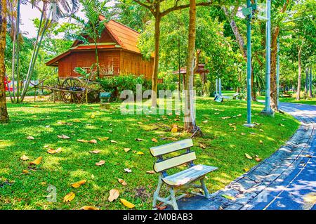 Kleine Holzbank in der Gasse im Saranrom Palace Park von Bangkok, Thailand Stockfoto