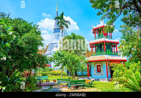 Kleiner chinesischer Chao Mae Takhian Thong-Schrein im Saranrom Palace Park und Chedi von Wat Ratchapradit im Hintergrund, Bangkok, Thailand Stockfoto