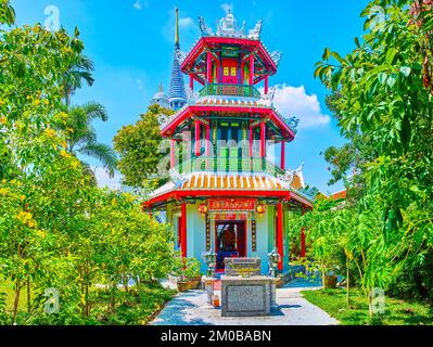 Fantastischer kleiner, farbenfroher chinesischer Schrein Chao Mae Takhian Thong und hoher Cheedi von Wat Ratchapradit im Hintergrund, Bangkok, Thailand Stockfoto