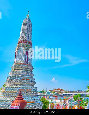 Die weiße Ecke Prang des Wat Arun Komplexes und der große Palast von Bangkok im Hintergrund, Thailand Stockfoto