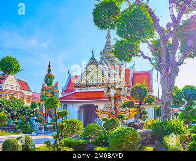 Farbenfrohe Statuen von Yakshas, den mythologischen Dämonenwächtern, stehen am Haupttor zum Wat Arun Tempel in Bangkok, Thailand Stockfoto