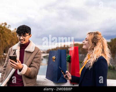 Selektiver Fokus arabischer Mann, der sich nach dem Einkaufen mit seinem Freund per Smartphone chattet Stockfoto