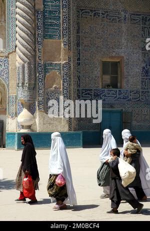 Balkh, Balkanprovinz/Afghanistan: Frauen, die Burka mit Kindern tragen, gehen am alten Schrein von Chwaja Abu Nasr Parsa (Grüne Moschee) vorbei Stockfoto