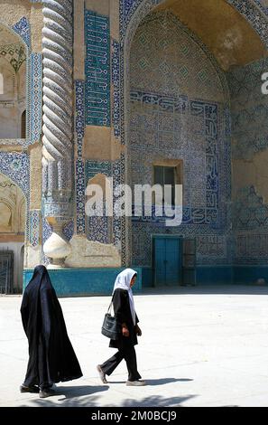 Balkh, Balkanprovinz/Afghanistan: Zwei Frauen gehen am uralten dekorierten Portal des Schreins von Chwaja Abu Nasr Parsa (Grüne Moschee) vorbei. Stockfoto