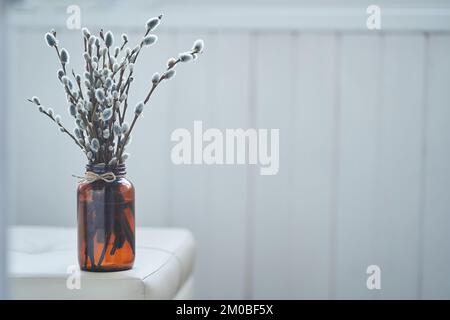 Ein Bouquet und du stehst am Rand des Tisches. Weide, flauschige Knospen, braune Glasvase. Palm Sunday Konzept mit Kopierbereich. Hochwertiges Foto Stockfoto