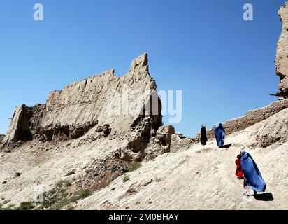 Ghazni/Afghanistan: Frauen und Mädchen gehen über die Mauer der Zitadelle von Ghazni. Die Frauen tragen blaue Burkas (Burkas), traditionell in Zentralafghanistan. Stockfoto