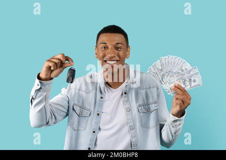 Fröhlicher, aufgeregter junger afroamerikanischer Mann zeigt viele Dollar in bar, in Händen, Autoschlüssel, Genießen Sie Kredit Stockfoto
