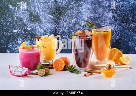 Auswahl an heißen Wintergetränken mit Obst und aromatischen Kräutern Stockfoto