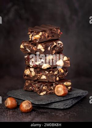 Makrofotografie mit schwarzer Schokolade, Haselnuss, Nuss, Cranberrys Stockfoto
