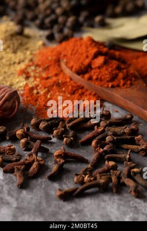 Indische Gewürzzehe mit Chilipulver und Korianderpulver im Hintergrund. Stockfoto